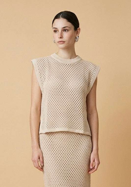 Model wearing the beige Alba set featuring a sleeveless open-knit crewneck vest top and a matching open-knit midi skirt