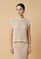 Model wearing the beige Alba set featuring a sleeveless open-knit crewneck vest top and a matching open-knit midi skirt
