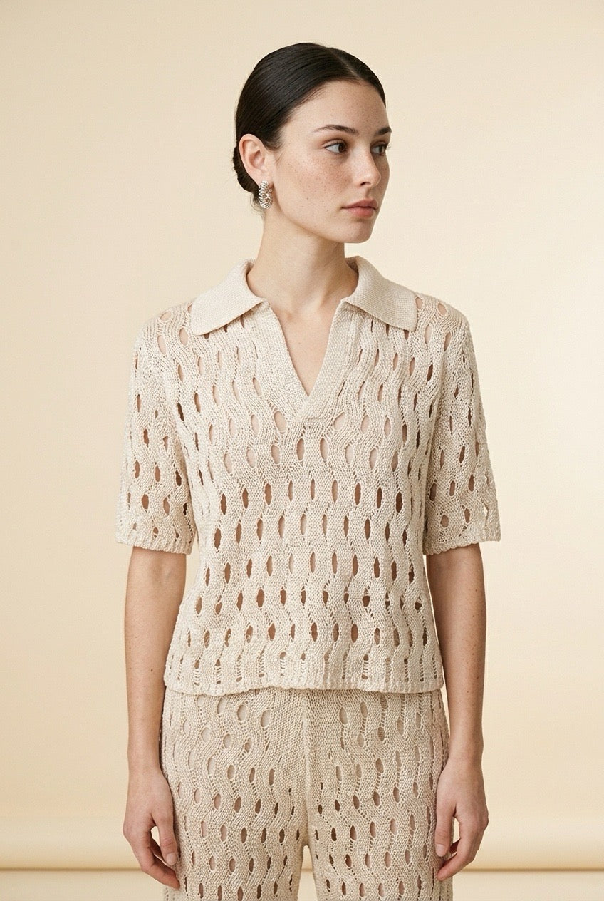 A woman wearing the Set Positano open-knit two-piece set in beige, featuring a collared polo top and matching wide-leg trousers.