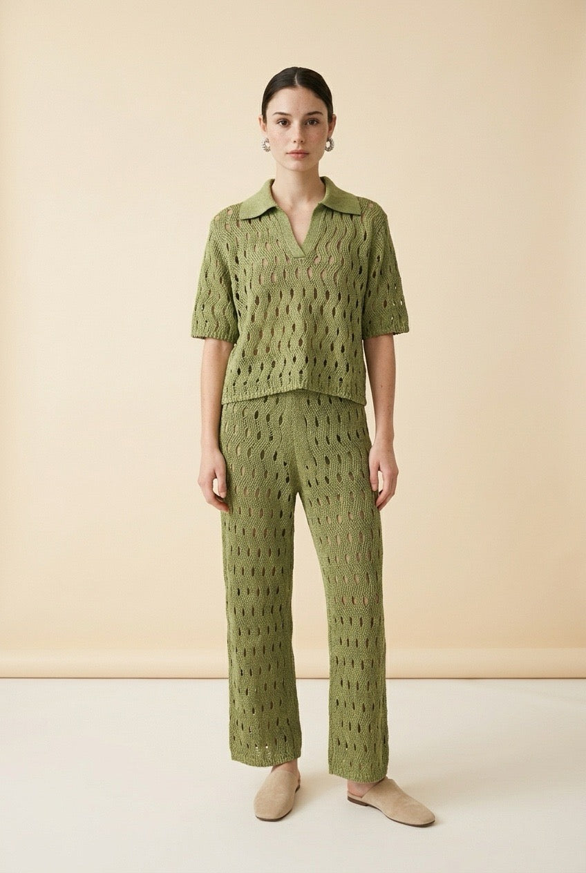 A woman wearing the Set Positano open-knit two-piece set in olive green, featuring a collared polo top and matching wide-leg trousers.