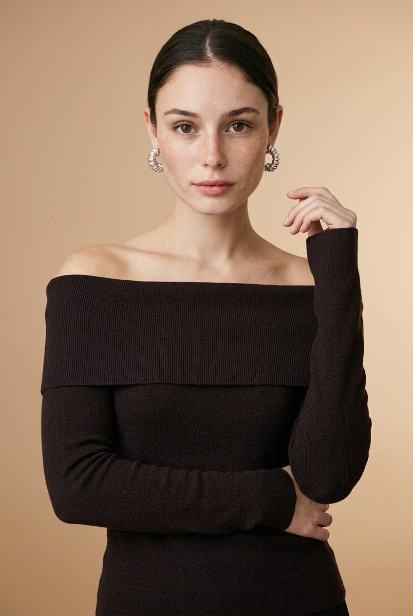 A woman wearing the Top Lecce off-the-shoulder knit top in black, featuring a foldover neckline and slim long sleeves.