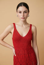 Model wearing the red Serena dress, a sleeveless V-neck knit maxi dress with a detailed lattice crochet skirt