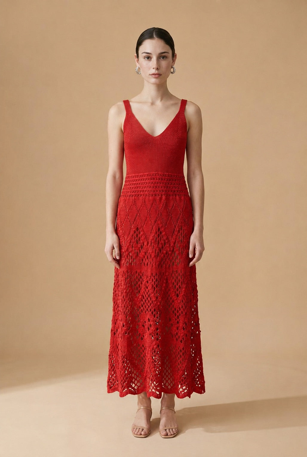 Model wearing the red Serena dress, a sleeveless V-neck knit maxi dress with a detailed lattice crochet skirt