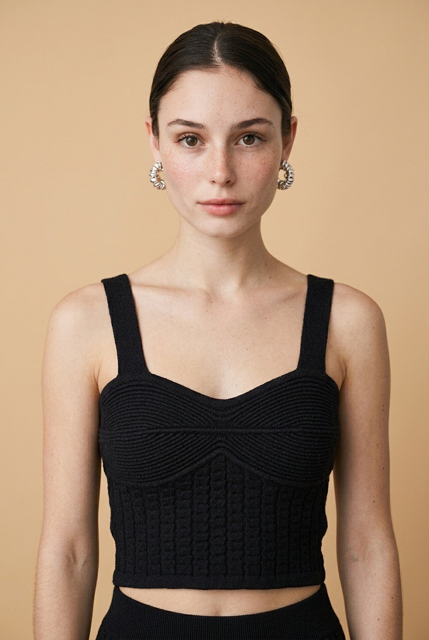 Model wearing the black Siena knit tank top featuring wide shoulder straps, a sweetheart neckline, ribbed bust detail, and a textured corset-style bodice