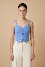 Woman wearing the Top Bloom knit crop top in cornflower blue with 3D flower petal detail and thin straps